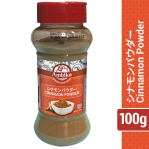 Clear plastic jar of Ambika Cinnamon Powder with a red cap, brown spice powder inside, and a label featuring Japanese text.