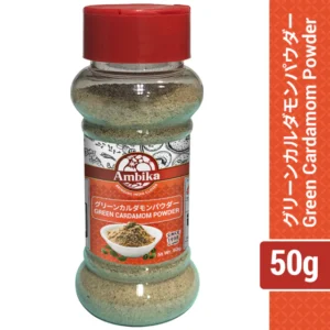 Clear plastic jar of Ambika Green Cardamom Powder with a red cap, light greenish-brown spice powder inside, and a label featuring English and Japanese text.