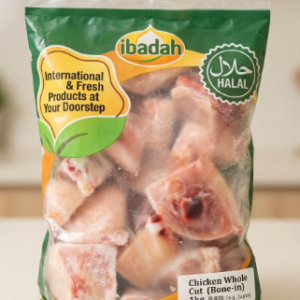 Front view of a clear, green, and orange ibadah plastic bag labeled Chicken Whole Cut 1kg, displaying a circular Halal certification logo at the top right and frozen meat pieces inside.